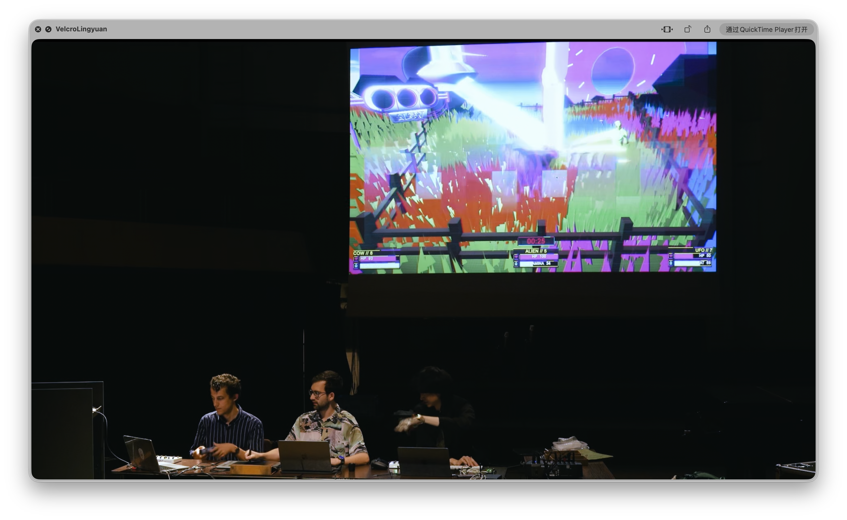 Three performers using controllers and electronics while the MOO.F.O. game is projected above them